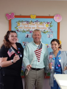 3 people holding flags