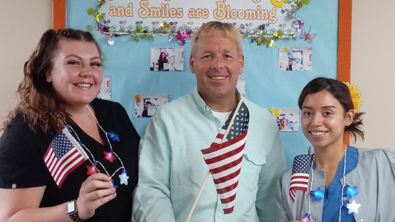 3 people holding flags
